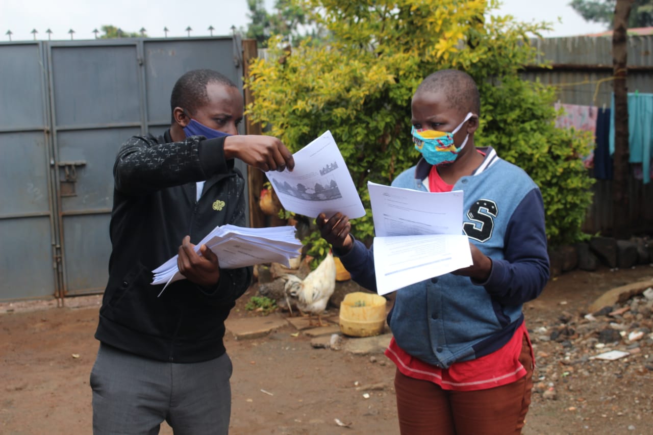 Teachers in Kenya’s Dignitas project distributing IFERB learning materials to parents